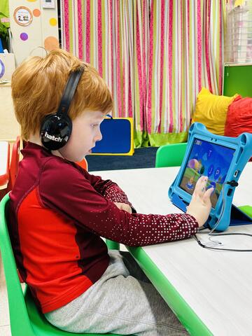 Sudduth student using an iPad and headphones