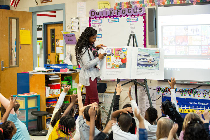 Teacher reading to class from a large book 